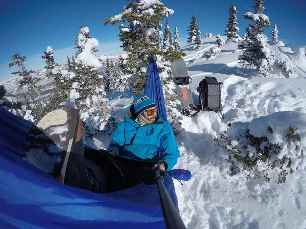 man hammocking in the snow on a mountain