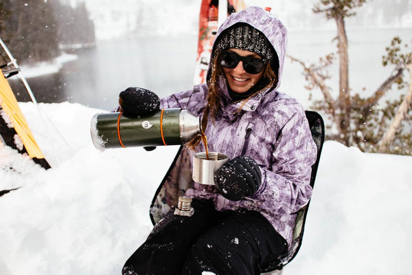 woman holding a thermus in the snow