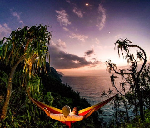 man hammocking on a cliff overlooking the sea