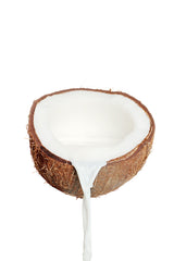 Fresh Coconut Milk Pouring from a Coconut Half