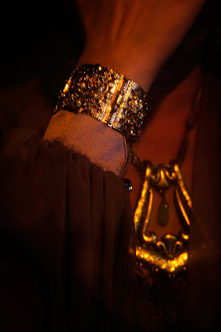 Close up of Icon Style gold bracelet and fringed necklace
