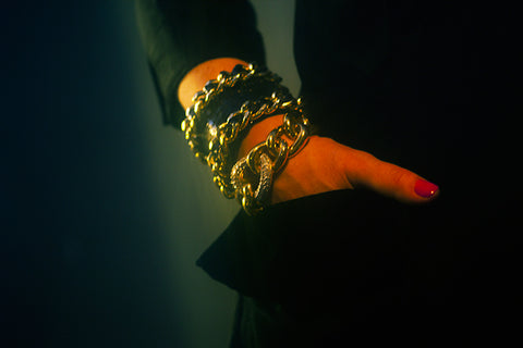 Hand in pocket with crocodile cuff bracelet with chain and Givenchy curb link bracelet