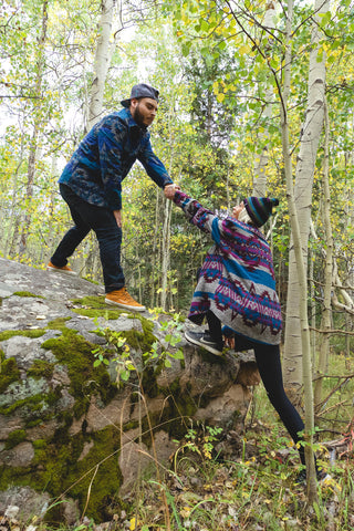 guy helping girl climb a rock in grassroots style