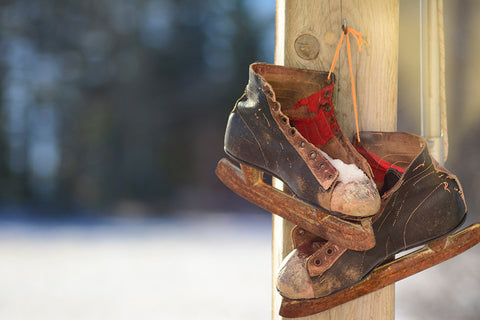 old black and white ice skates hanging on a post