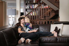 Mother, father and child wearing Nuknuuk slippers on the couch