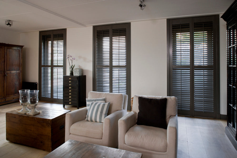 modern living room with dark stained window shutters in the background