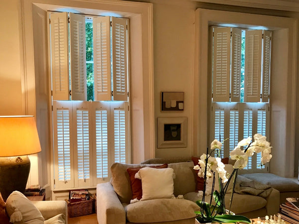 detail of half closed tier on tier wooden shutters in an elegant living room