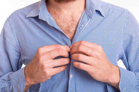 man buttoning shirt with body hair