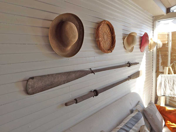 hats and oars hanging on an indoor-outdoor wall
