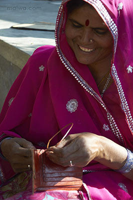 A woman sews a wallet - Jawaja