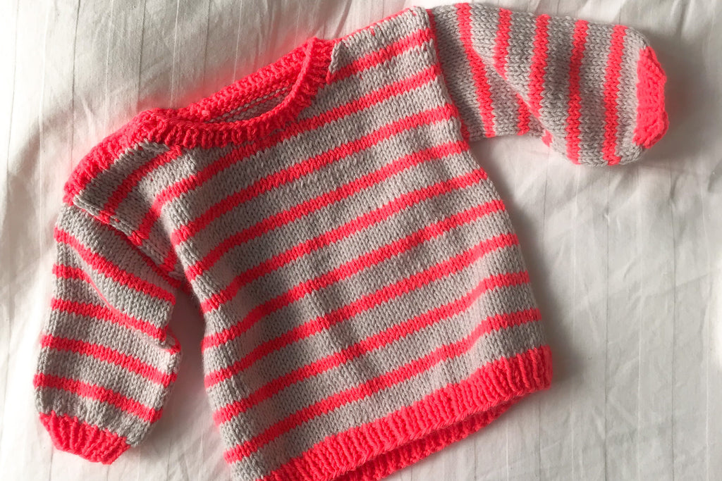 Striped baby sweater in grey and neon coral