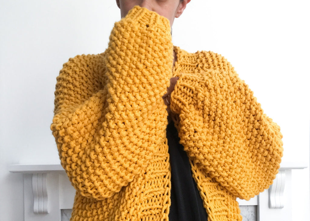 Sleeves of oversized yellow knit cardigan