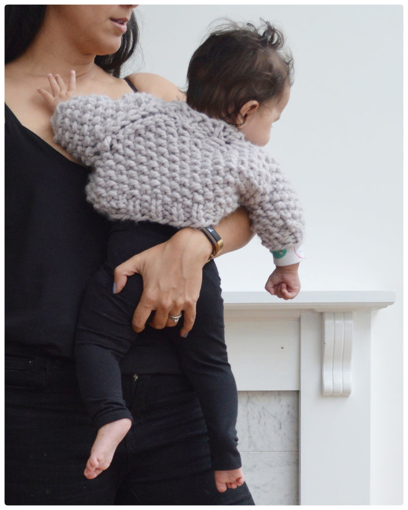 Baby in oversized lavender knit sweater