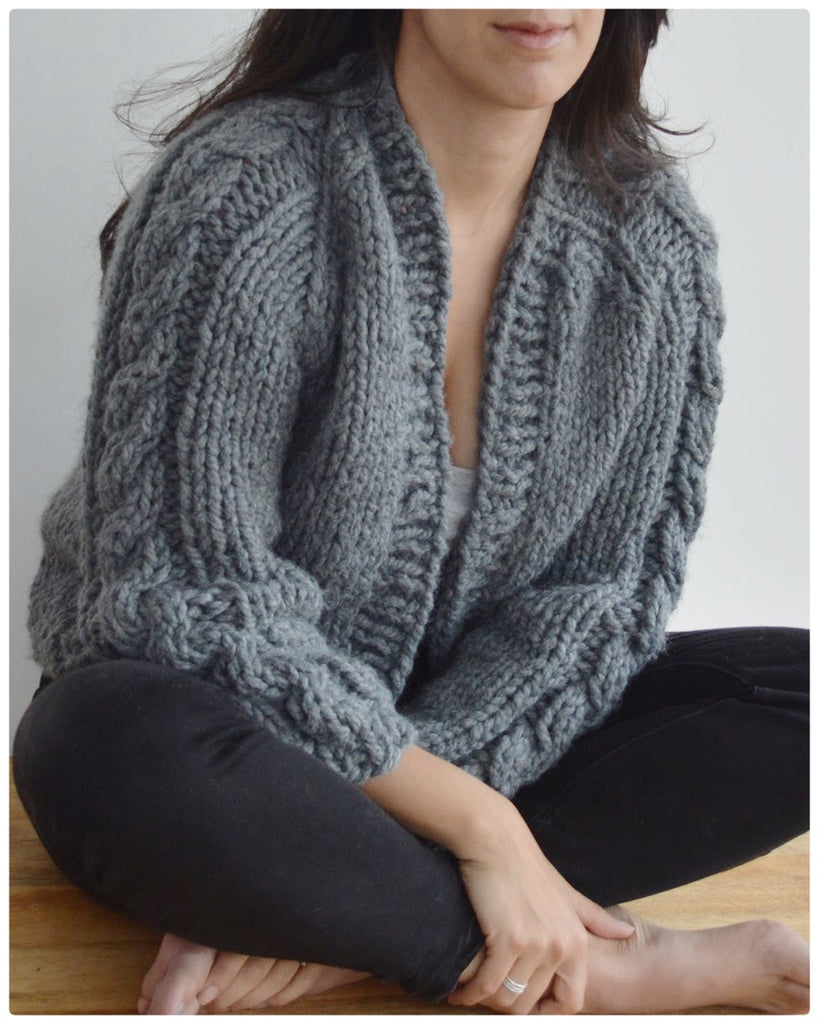 Close up of woman wearing grey cable sleeved cardigan 