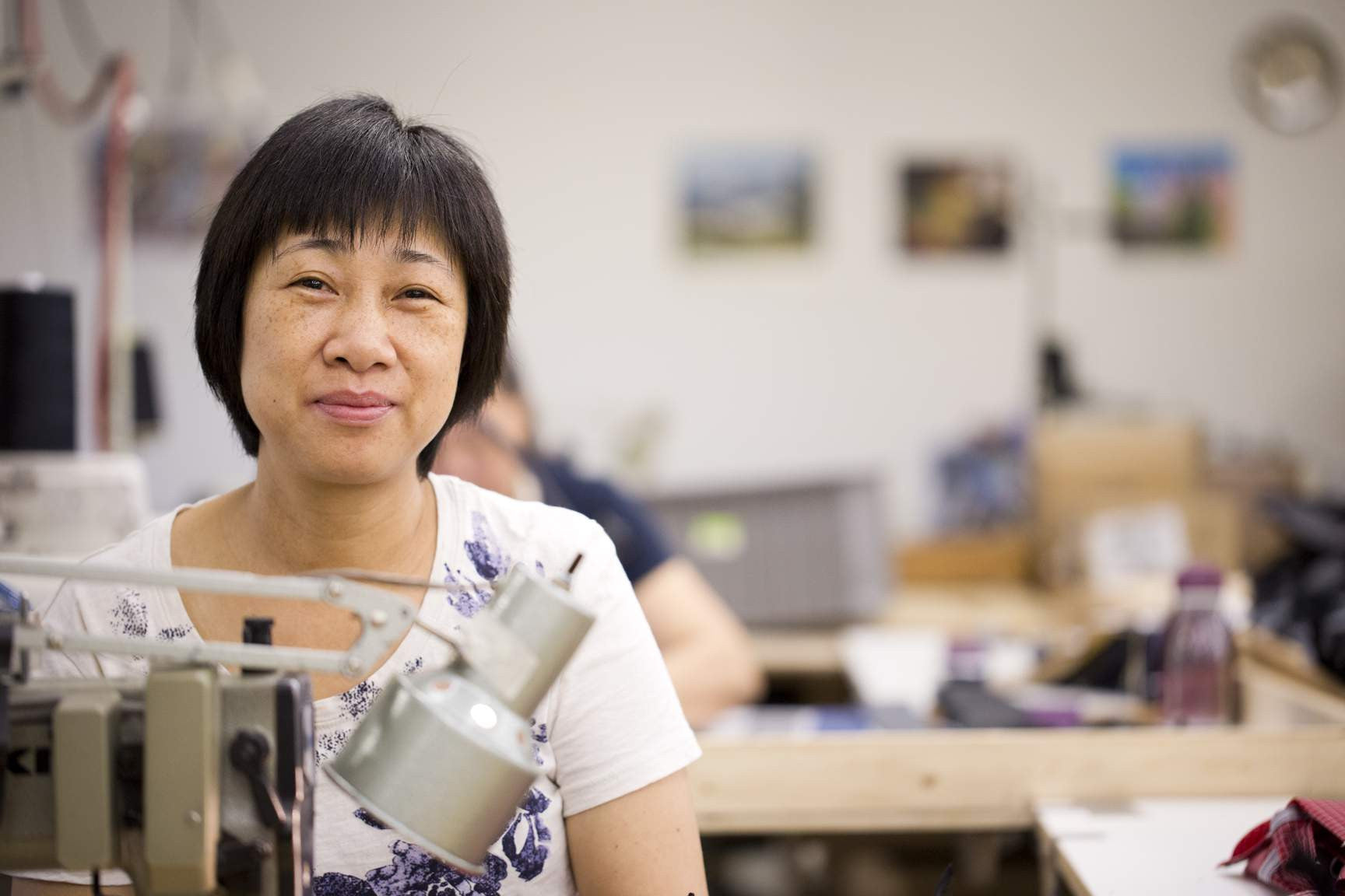 Yan Hua sitting at her sewing machine