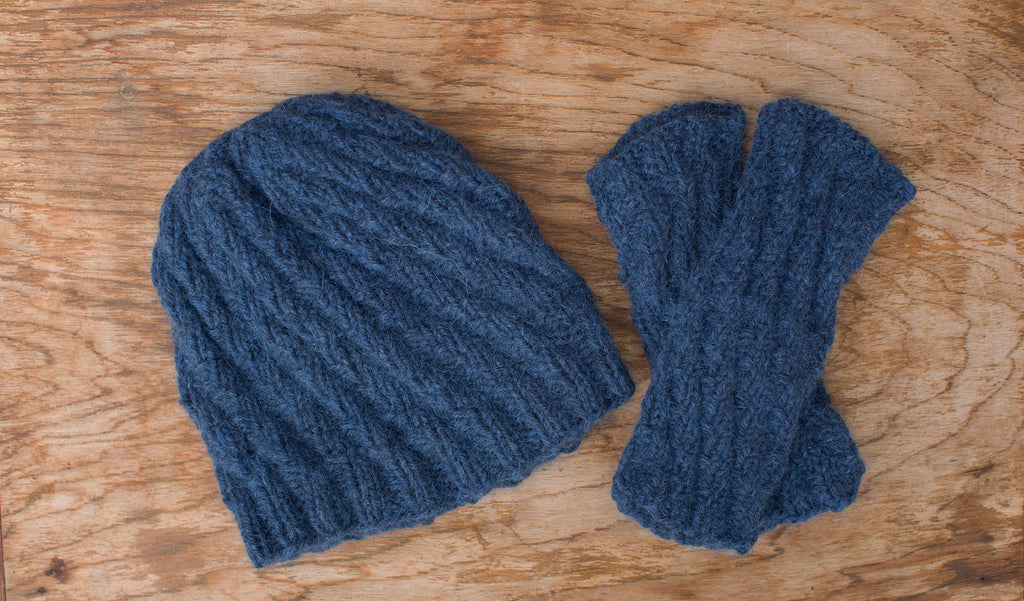 Matching medium-blue knit cap and fingerless gloves. Handmade by the TOM BIHN Ravelry group for the TOM BIHN crew.