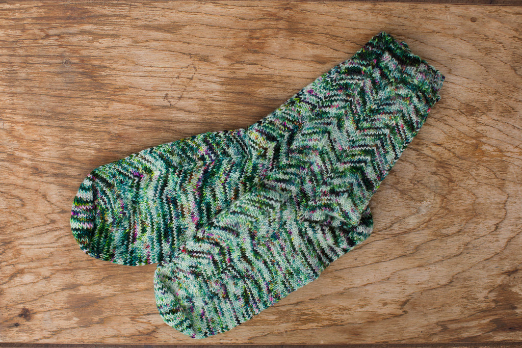 Multi-color green, blue, white knit socks. Handmade by the TOM BIHN Ravelry group for the TOM BIHN crew.