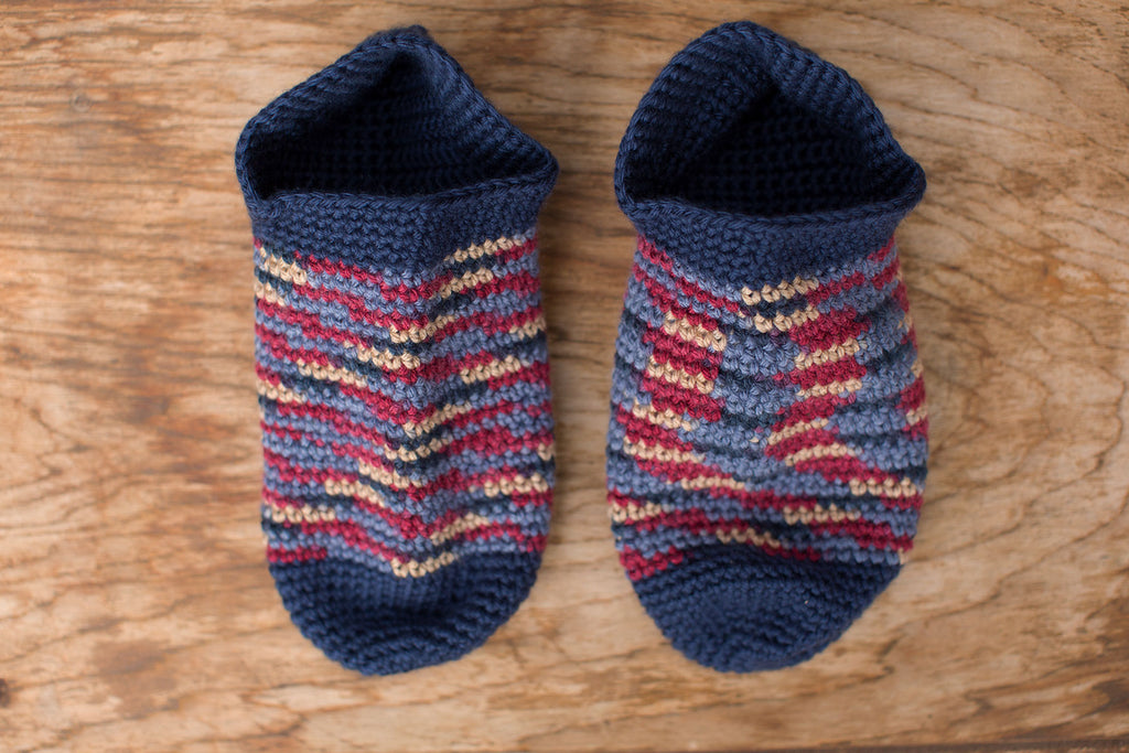 Navy, red, and yellow knit slippers. Handmade by the TOM BIHN Ravelry group for the TOM BIHN crew.