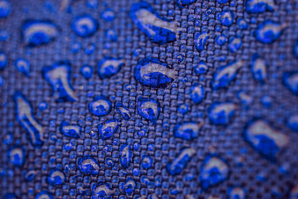 Water beading up on a blue fabric.