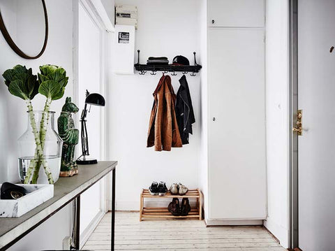 Entry way with a console table, coat racks and a cabinet