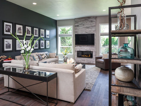 Modern living room with dark green wall, wooden floor, cream sofa and fireplace