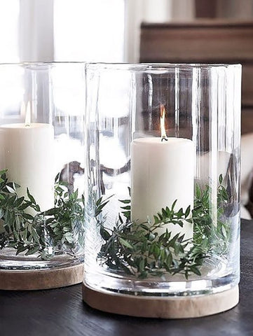 2 candles in a glass jar with wooden base