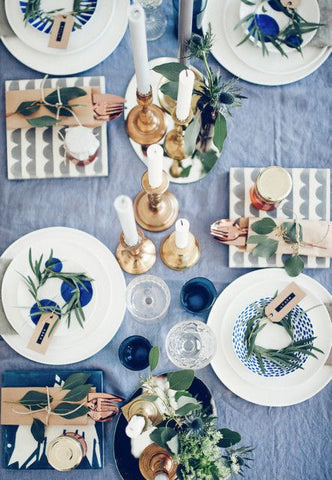 Table setting on blue table cloth with rose gold cutleries