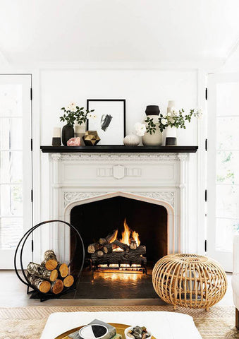 Light lofty fireplace with ornaments around.