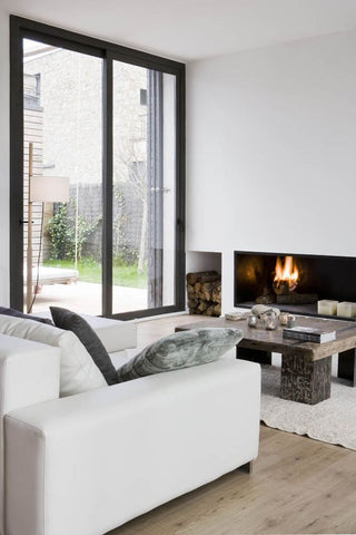 Living room with white sofa, floor to ceiling windows and a fireplace