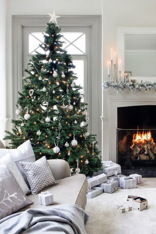 Living room with fireplace, Christmas tree, grey sofa and cushions