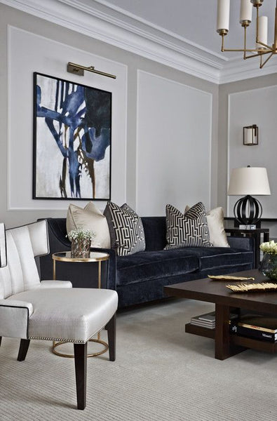 Formal living room with navy blue velvet sofa and white occasional chair