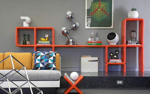 Retro living room with sophisticated midcentury design, orange shelves and Robert Sonneman atomic lamp