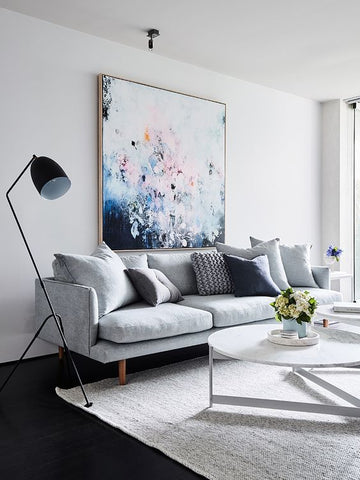 Living room with grey sofa and large painting on wall