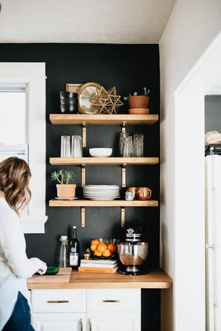 light brown Kitchen shelves against a black wall