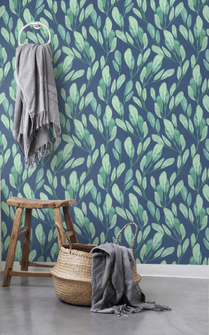 Bathroom wall with tranquil removable wall art of green leaves on a blue background.