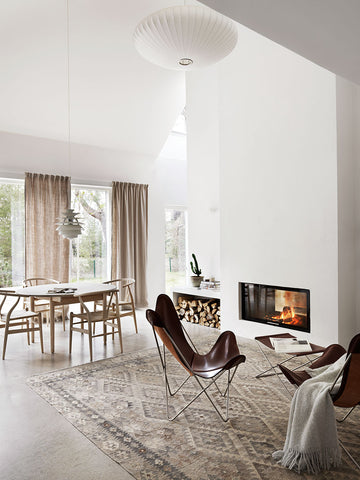 Brown leather butterfly chairs in front of fireplace