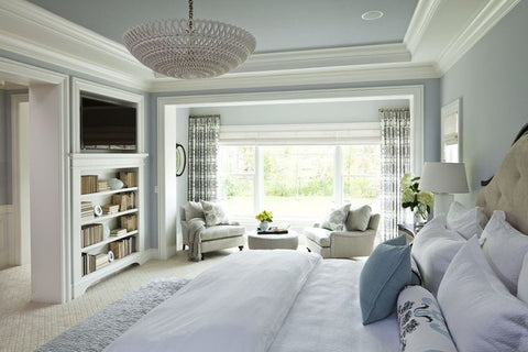 Bedroom interior with light blue walls, built-in shelf and decorative cornices