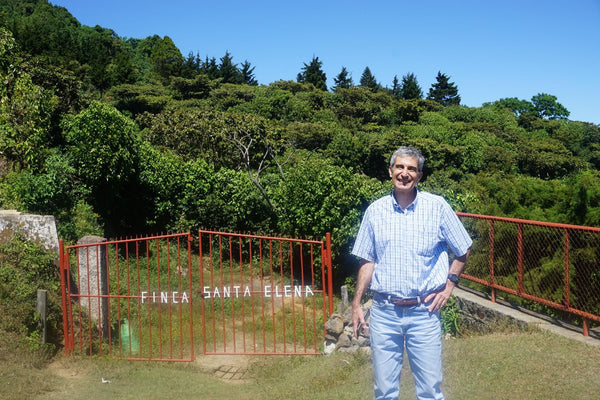 Fernando Lima standing by gates of his farm, Santa Elena