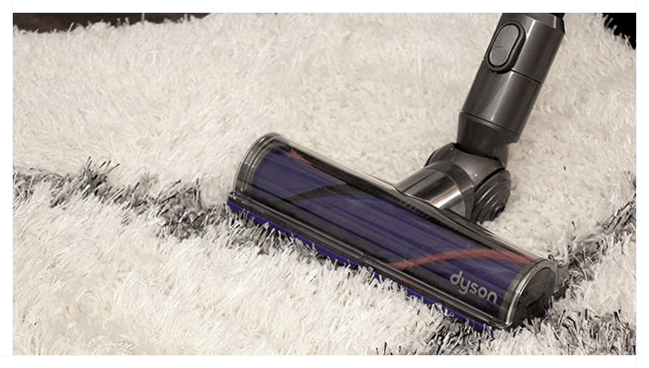 A shag rug being vacuumed