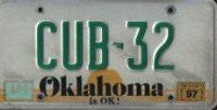 Oklahoma is OK License Plate green numbers on white with Yellow Sunset