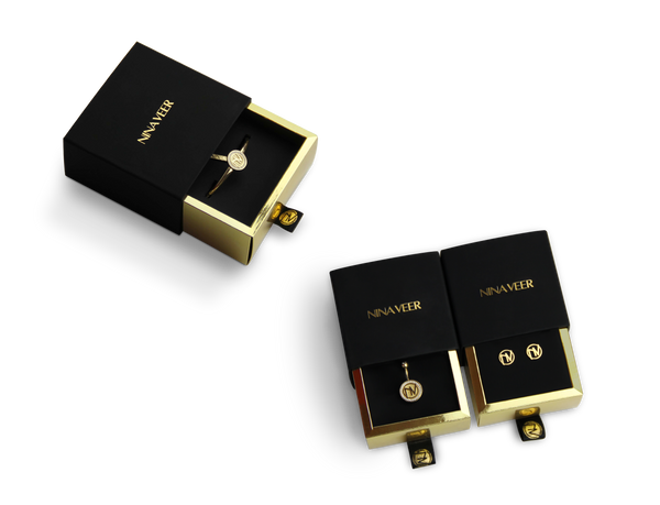Nina veer black outside, gold inside rigid sleeve boxes with black ribbon and hot foil stamped logo