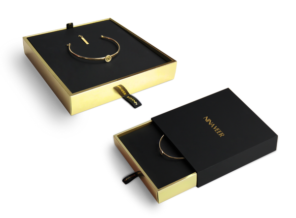 Nina veer black outside, gold inside rigid sleeve boxes with black ribbon and hot foil stamped logo