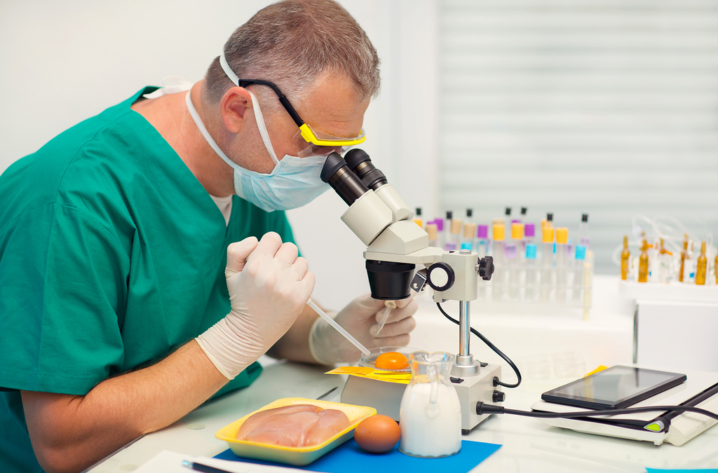 scientist analysing food specimens under a microscope