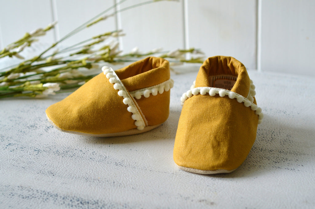 yellow pom pom baby shoes