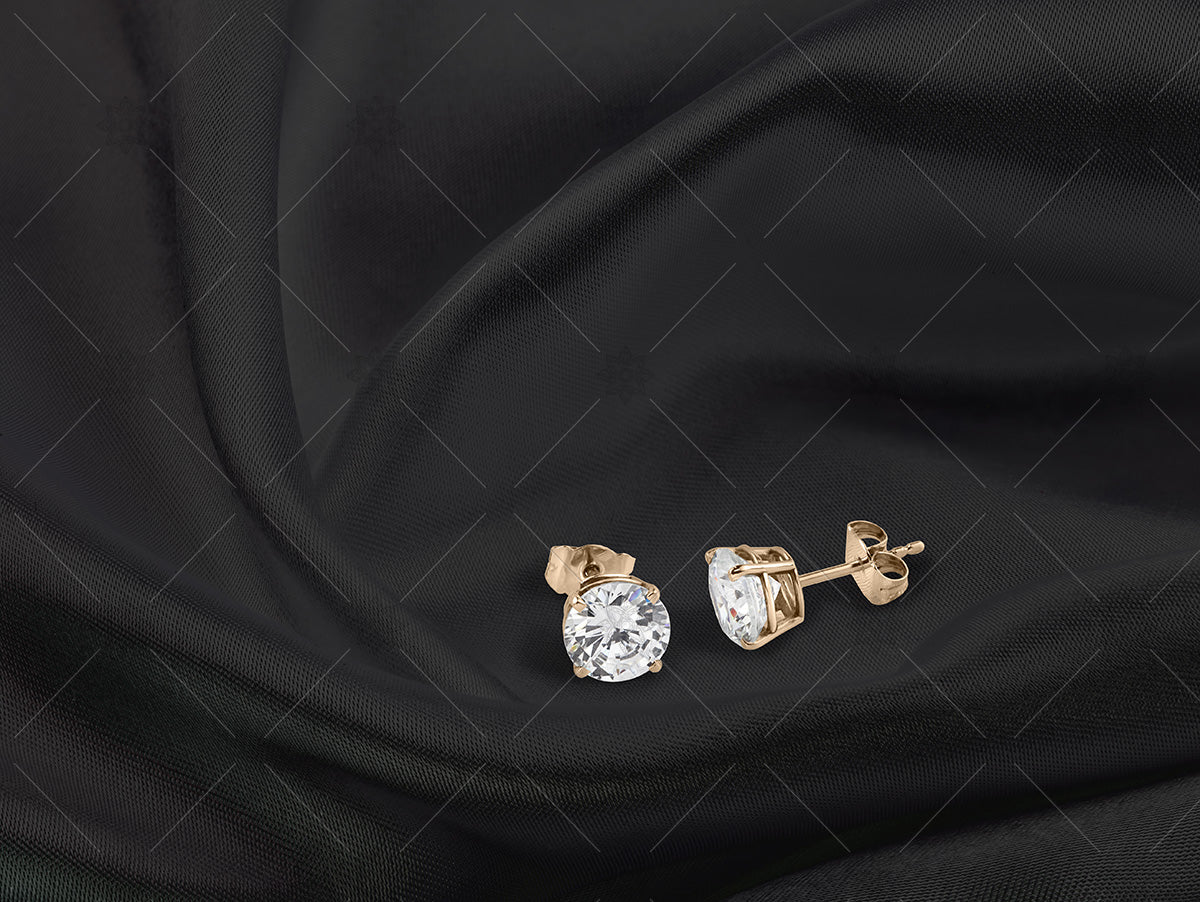 yellow gold diamond stud earrings on black silk