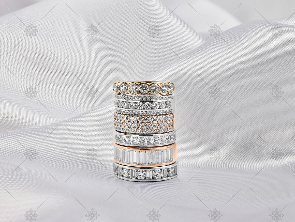 gold eternity ring stack on white silk background