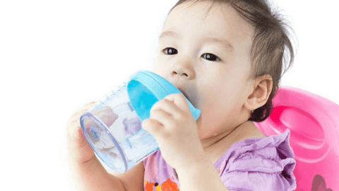 a baby using a sippy cup, how to introduce sippy cup, introducing sippy cup | The Spoiled Mama