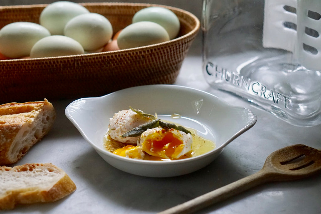 Poached eggs, baguette and Churncraft butter churn on counter