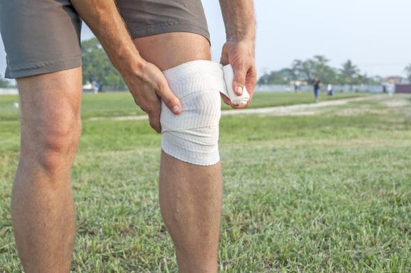 A man is wrapping an injured knee