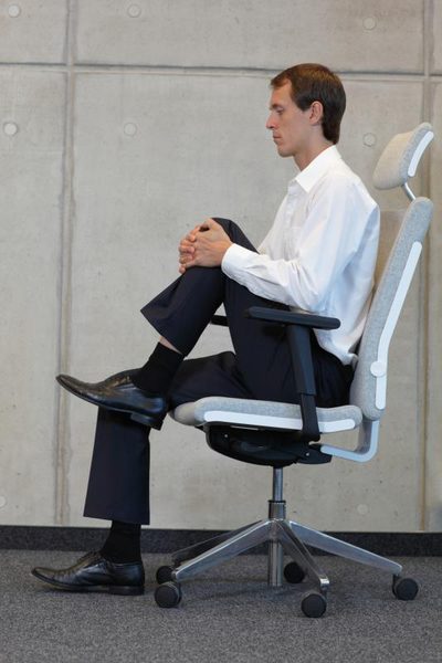 Man doing leg exercises in chair.
